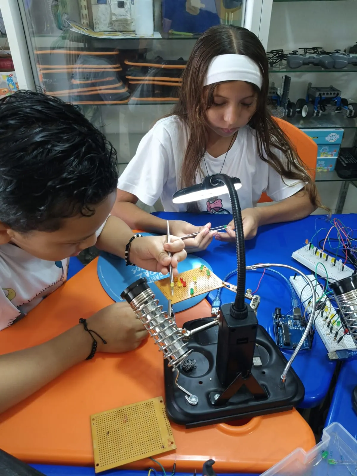 Dos estudiantes sueldan componentes electrónicos